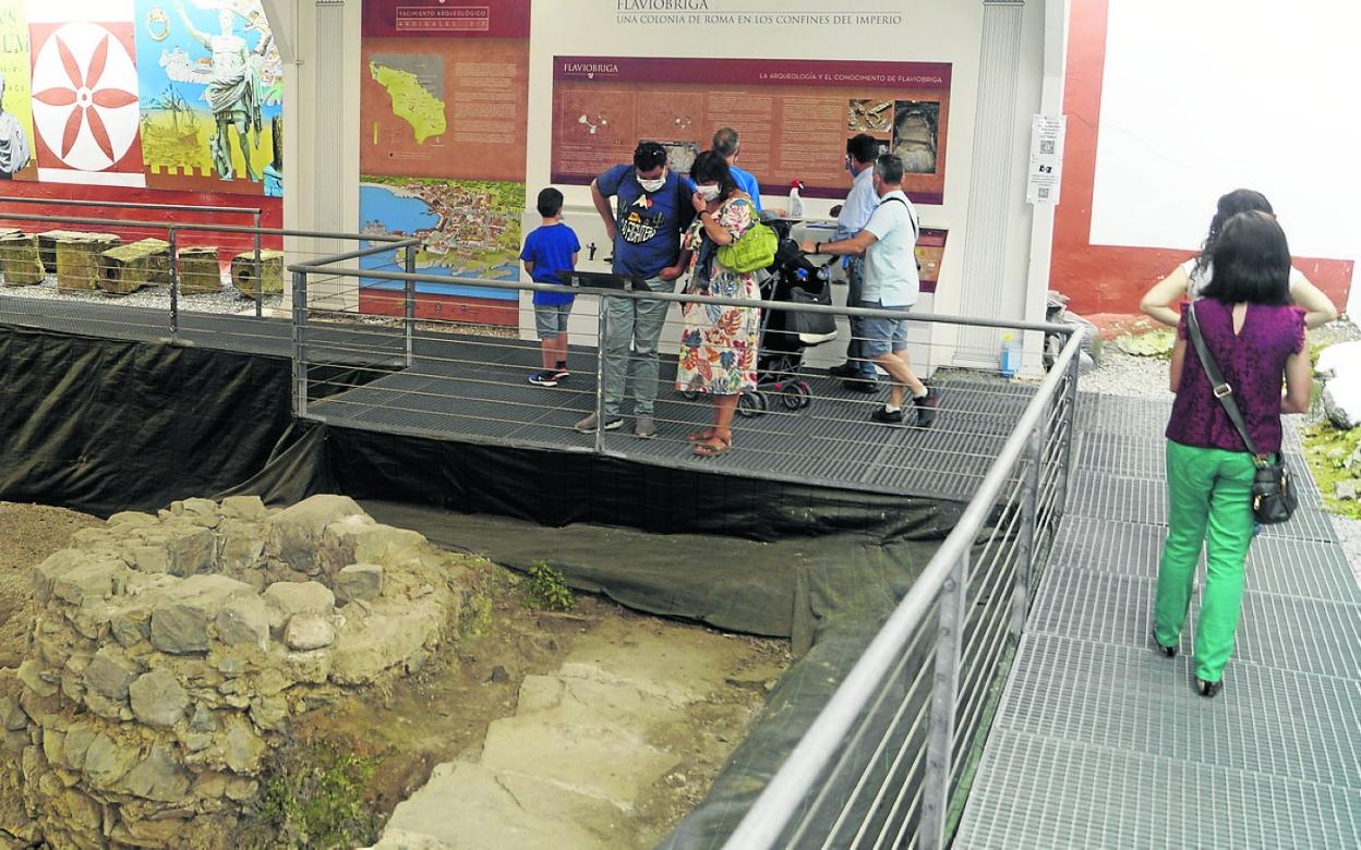 Un grupo de turistas visita el yacimiento romano de Flavióbriga, situado en la calle Ardigales. 