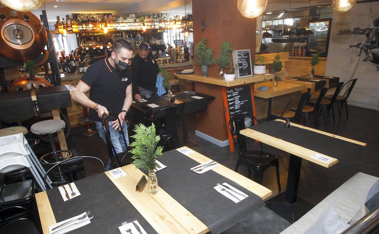 Dos trabajadores de un restaurante santanderino colocan las mesas