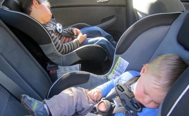 Imagen de dos niños en sus sillas infantiles para el coche