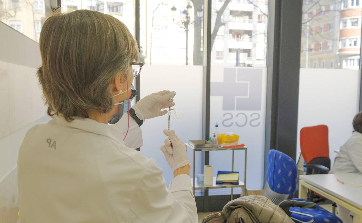 Una enfermera prepara una dosis de vacuna en un centro de salud.