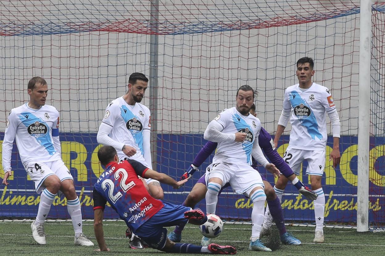 Cuatro jugadores del Deportivo intentan impedir un remate a puerta en un partido en Langreo. Los gallegos apuntan a ser uno de los rivales del Racing en Primera RFEF. 