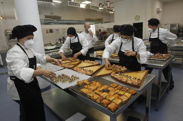 Alumnos del Taller de Empleo trabajan en la cocina. 