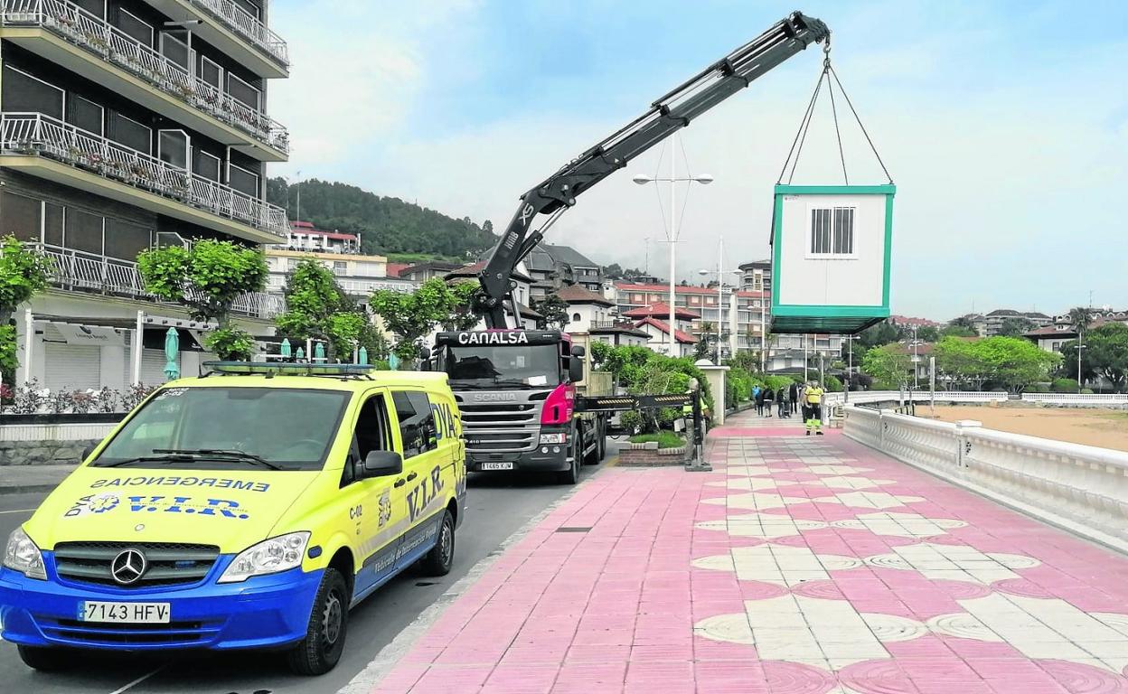 Un camión grúa instala el módulo que albergará el Servicio de Socorrismo y Salvamento en la playa de Brazomar. 