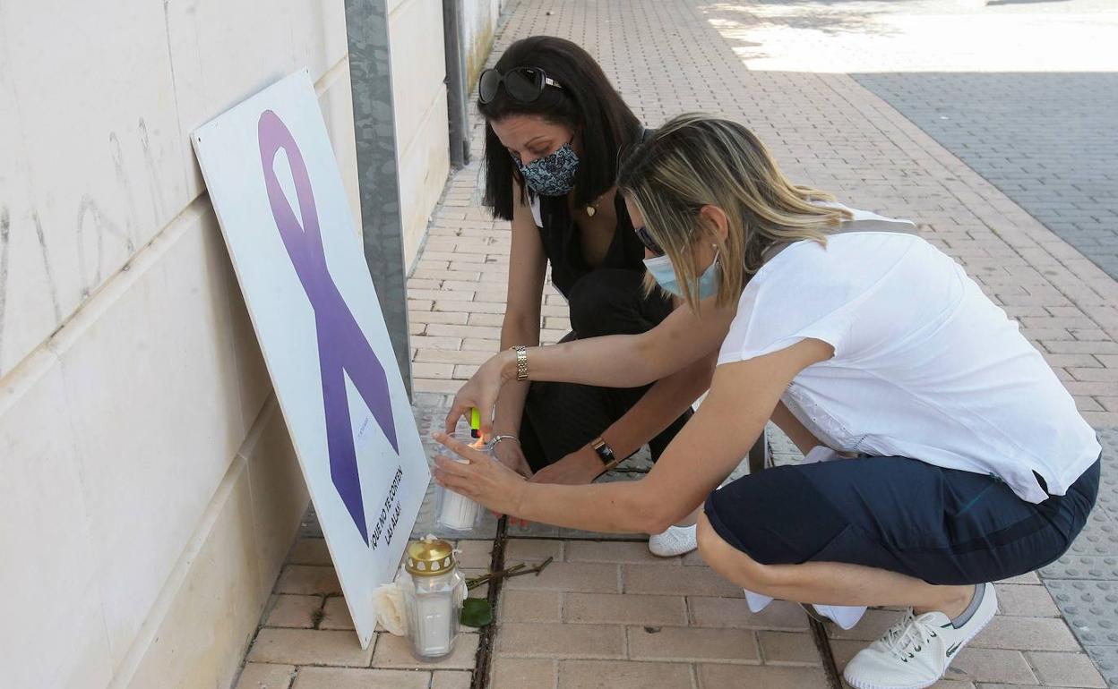 Dos mujeres encienden velas durante la concentración en repulsa por un asesinato machista ocurrido en Alovera (Guadalajara). 