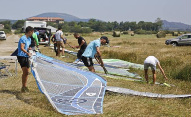 Deportistas preparan las velas en uno de los accesos al pantano. 