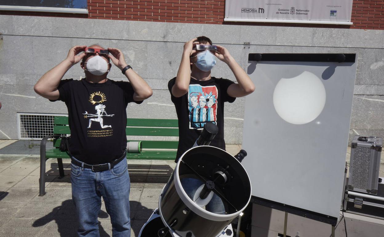 Dos personas observan el eclipse parcial de sol que se produjo ayer por la mañana, provistas de las correspondientes gafas 