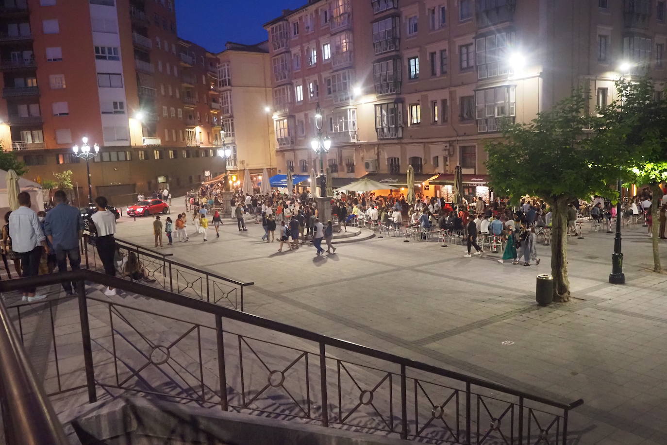 Un grupo de jóvenes beben sentados en una mesa.