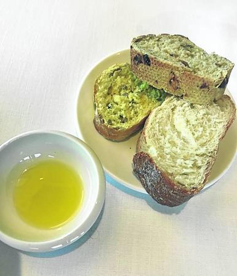 Bienvenida. Acomodo en la mesa, un aceite de Navarra, tres tipos de pan, agua de km 0. 