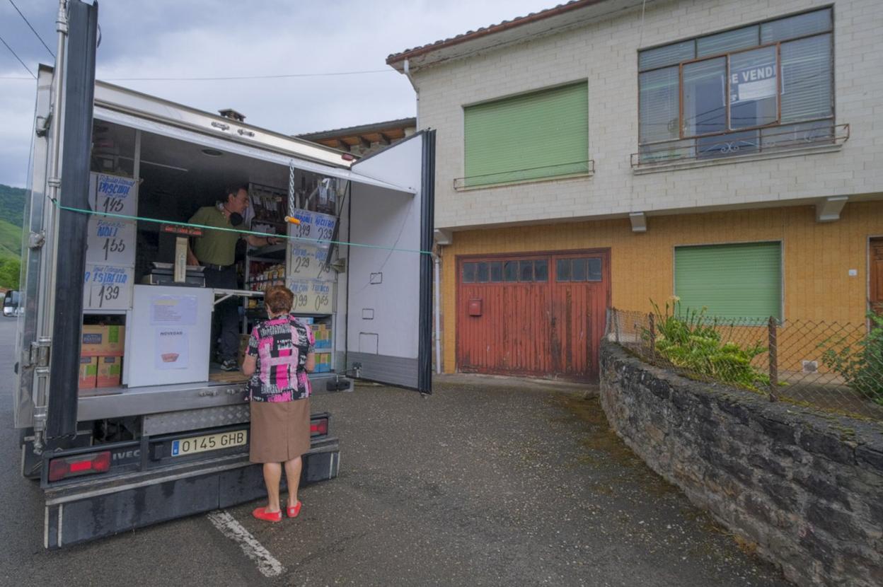 Una vecina del pueblo acude al puesto ambulante de José Luis Pérez, estacionado en mitad de la localidad de Villayuso.