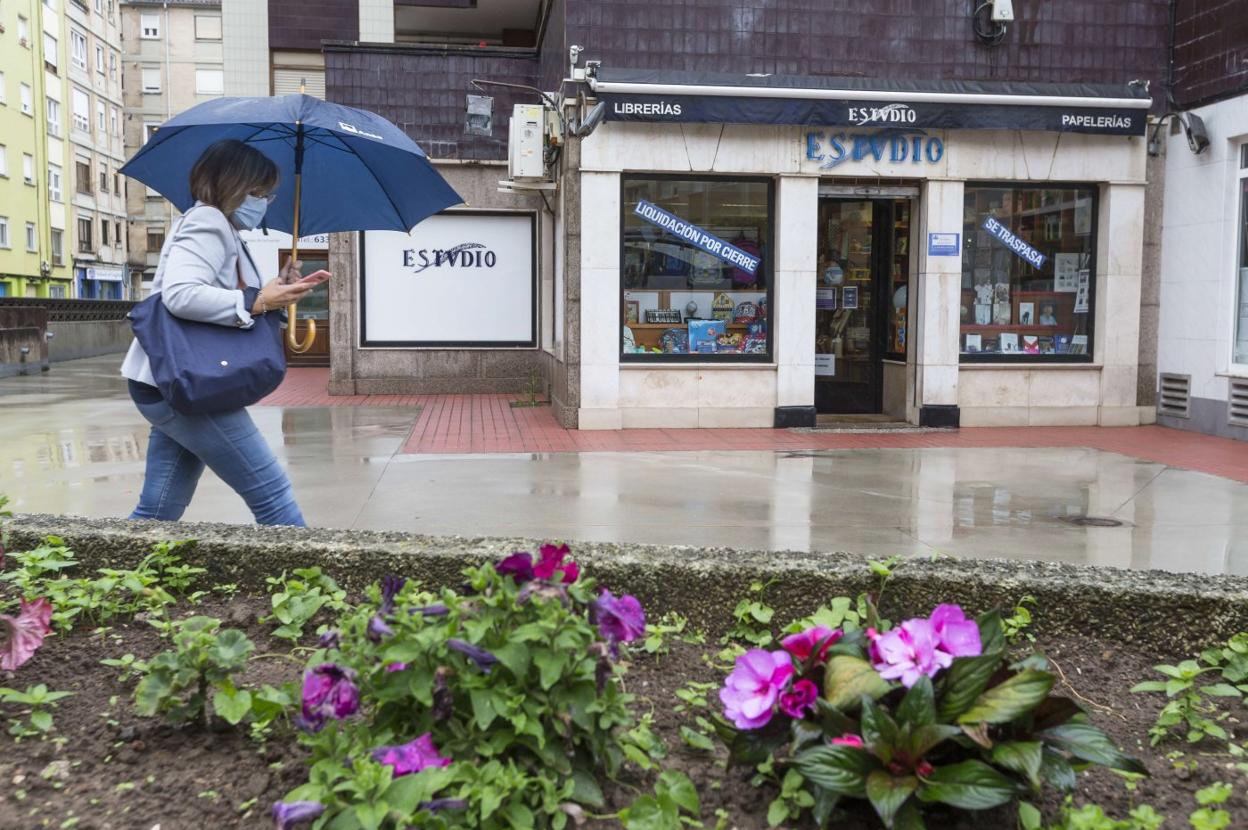 Una mujer camina por delante del local de la librería Estvdio, ayer, en Muriedas. roberto ruiz