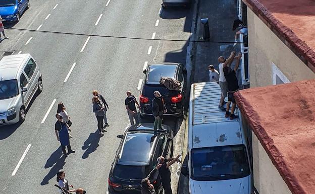 Momento en el que la menor salta por el balcón y dos vecinos le ayudan subidos a una furgoneta.