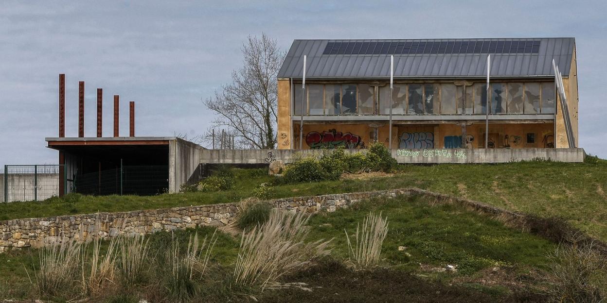 A la izquierda, las instalaciones inacabadas de Escenario Reocín y, a la derecha, el edificio principal tapiado y destrozado por los vándalos. 