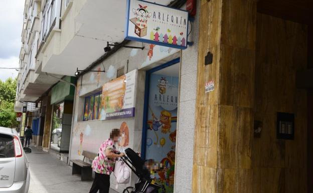 Una anciana pasa con un carrito de niño a la Escuela Infantil Arlequín, donde hoy ha fallecido un bebé por causas naturales. 