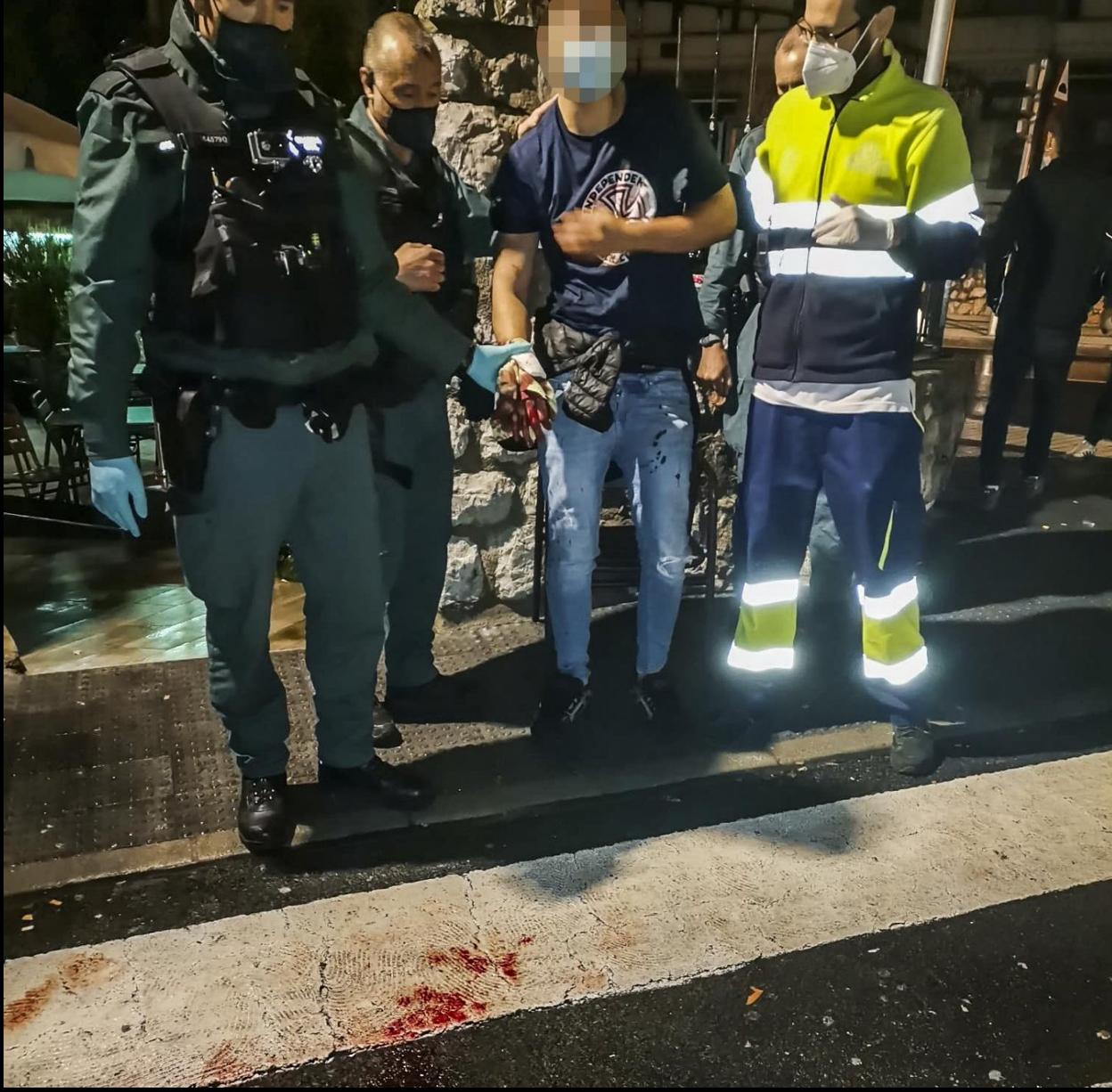 El joven, junto a los agentes de la Guardia Civil que le auxiliaron, a la llegada de la ambulancia. 