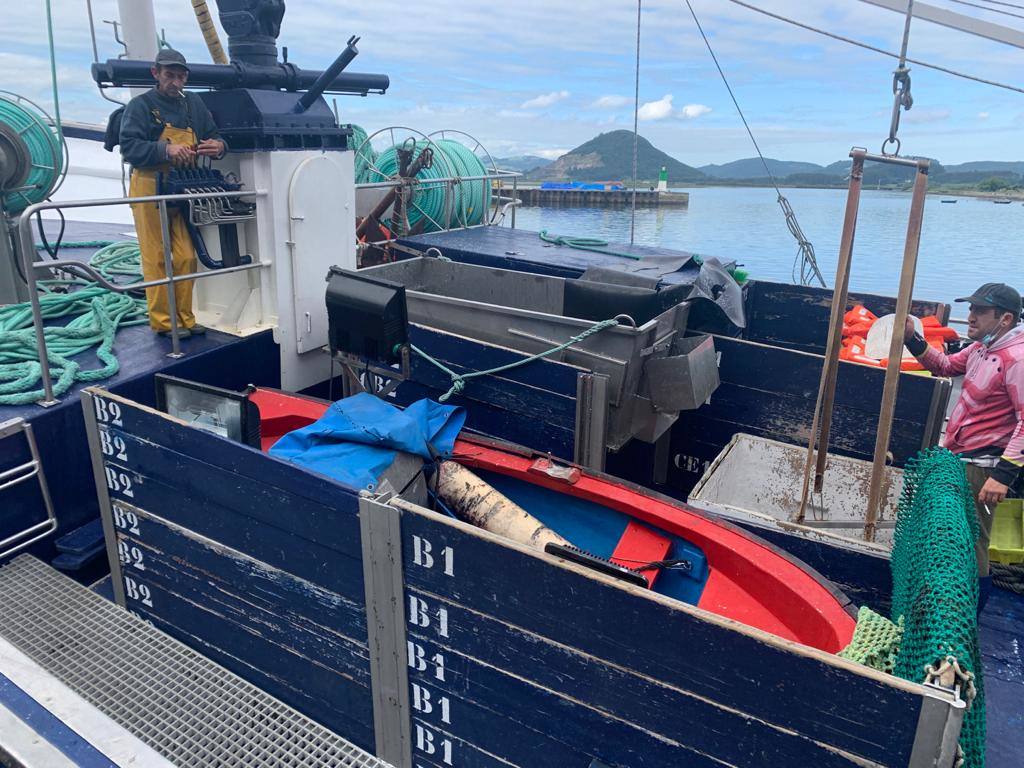 Momento en el que el Siempre al Alba, pesquero que rescató a cinco de los tripulantes del Maremi, llega al puerto de Santoña con un bote del barco siniestrado y chalecos salvavidas de los marineros, material que pudieron sacar del agua