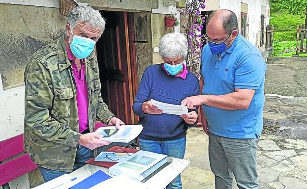 Francisco y Rosa revisan documentación junto al alcalde de Villafufre.