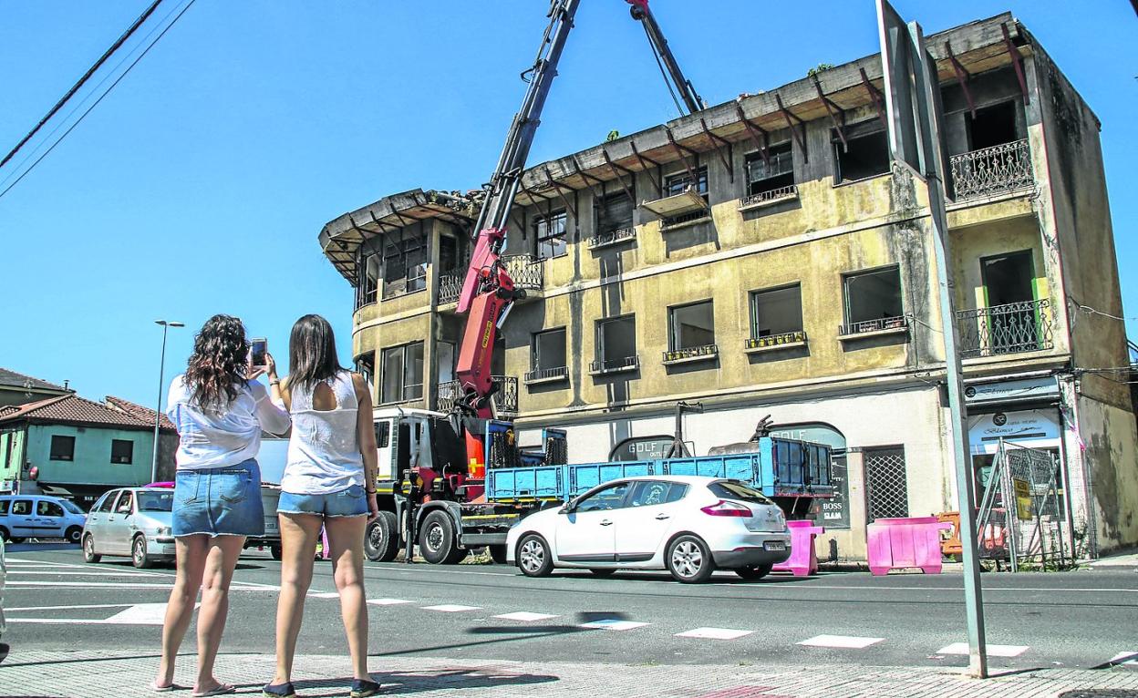 Ayer varios transeúntes se detuvieron a observar y fotografiar el inicio de los trabajos de derribo, que han comenzado por el tejado. H. Ruiz