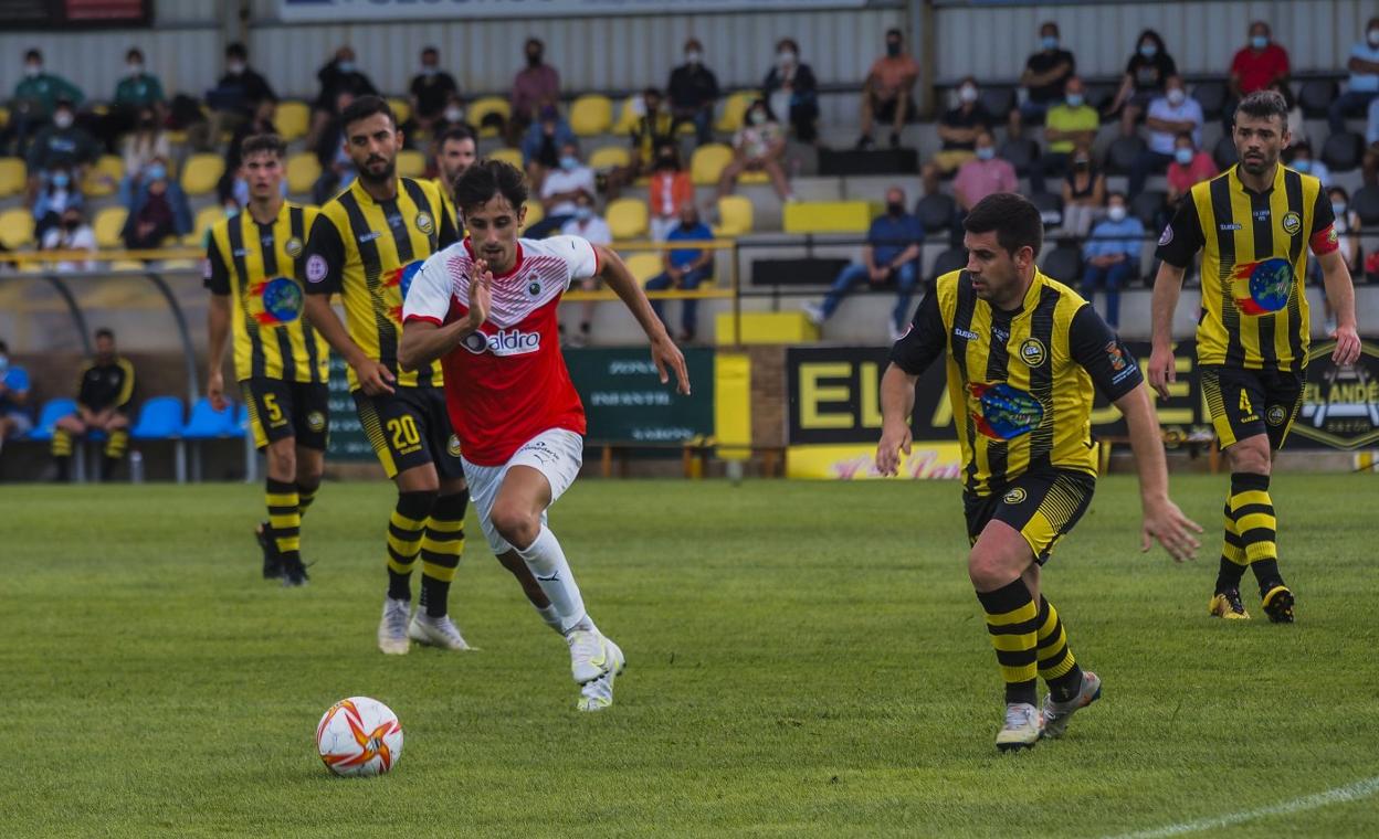 Marco Camus pelea el balón con Víctor Fernández. Al fondo, Miguelín, Marcos y el capitán local, Álex Bolado. sane