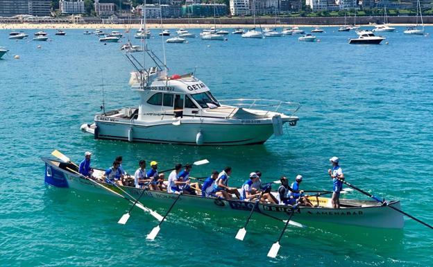 El yate que recorre la costa guipuzcana se cruza con una trainera en La Concha.