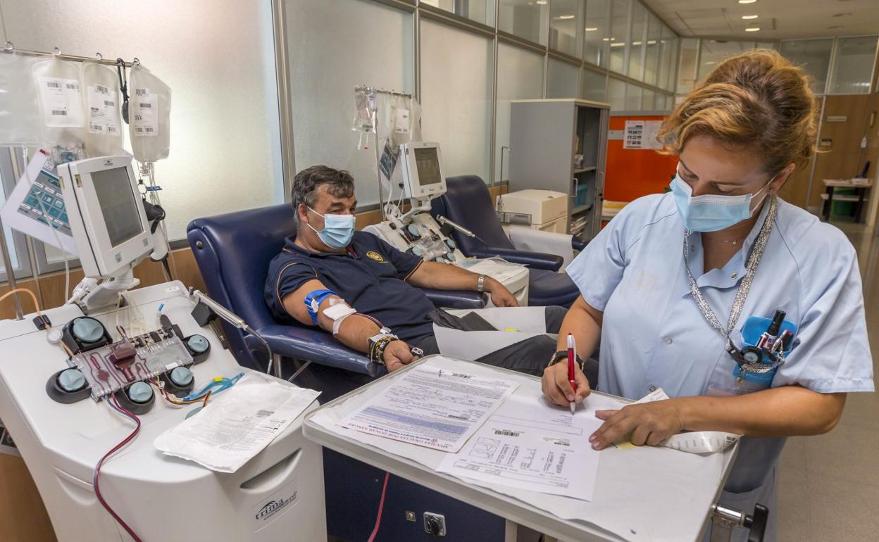 Alberto Revilla, durante el proceso de donación por aféresis, que ya ha realizado 84 veces. A su lado, la enfermera Andrea Ruiz