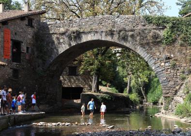 Imagen secundaria 1 - El Saja, a su paso por Santa Lucía, en Cabezón de la Sal. Los turistas cruzan el río Quiviesa, en Potes, junto al puente de San Cayetano. Unos niños se lanzan al pantano de Ebro, en Campoo.