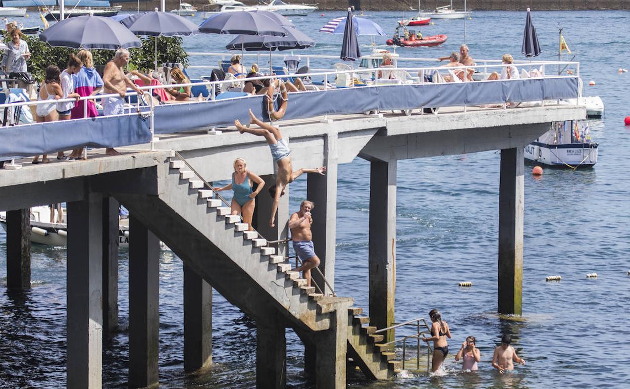 Mientras unos toman el sol en el Club Marítimo de Castro, los más jóvenes se lanzan desde arriba directos al agua, sin pasar por las escaleras.