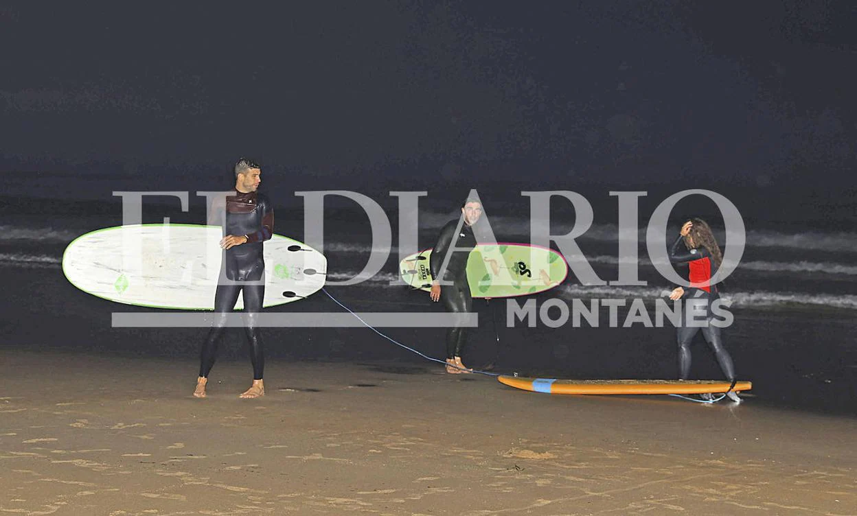 Piqué, a la izquierda, y Shakira, junto a un acompañante, después de hacer surf en la playa de Oyambre. javier rosendo