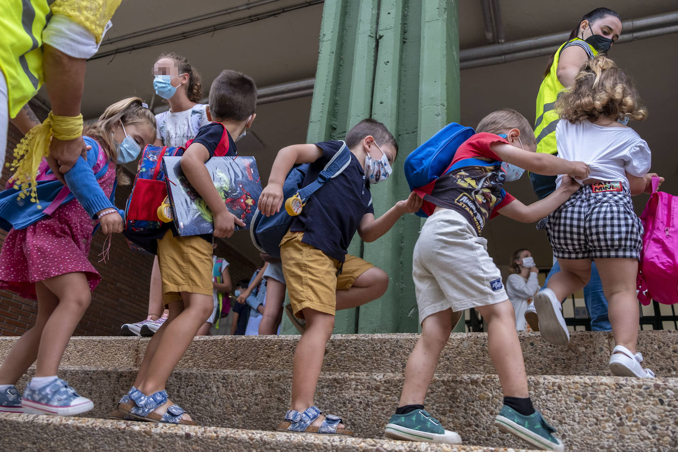 Varios niños y niñas se preparan para entrar a clase en el CEIP Gerardo Diego, en Santa María de Cayón