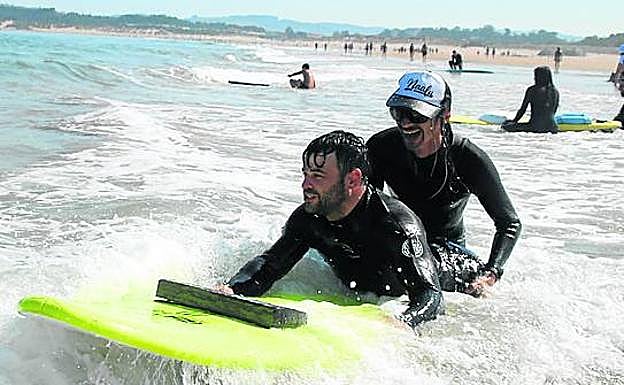 Isma Escalada prueba la tabla que Thomas Heller (atrás) le ha preparado de cara a su primer Campeonato Nacional de Surf Adaptado. 