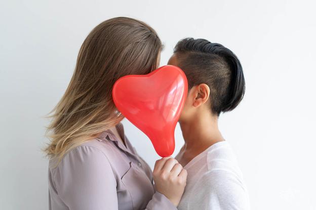 Dos chicas entregadas a un beso que sale del corazón. 