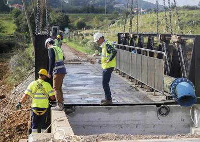 Imagen secundaria 1 - Recolocada la pasarela del puente de hierro de Solía tras reforzarse los cimientos