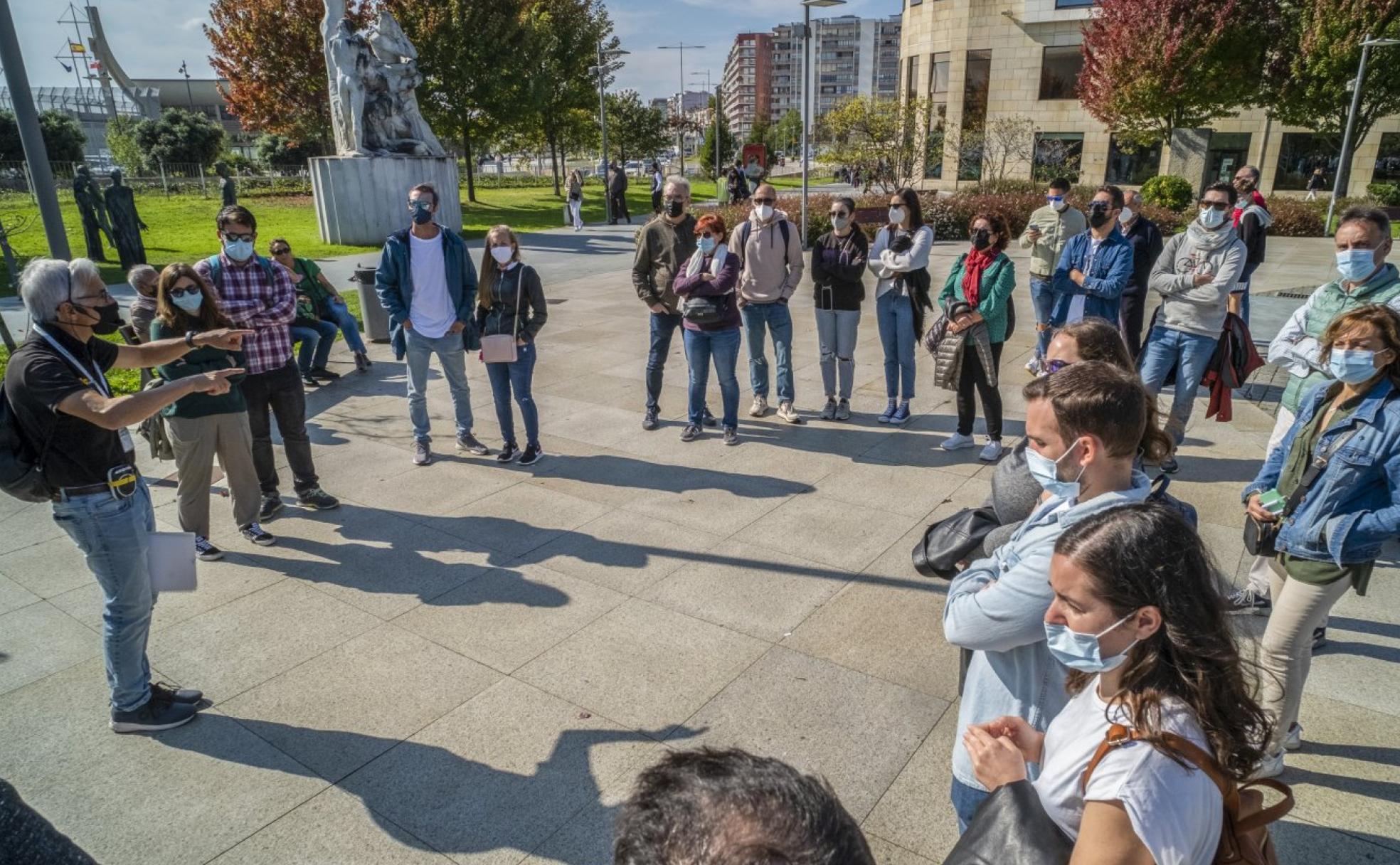 Un grupo de visitantes atiende las explicaciones del guía turístico, ayer por la mañana, en los alrededores del Centro Botín durante su visita a Santander. 