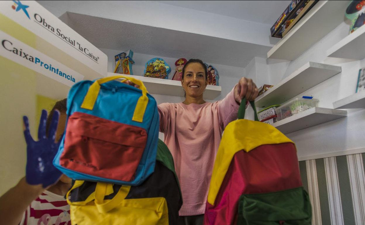 Irene Sánchez, con las mochilas de CaixaProinfancia, en la sede de Cantabria Acoge.