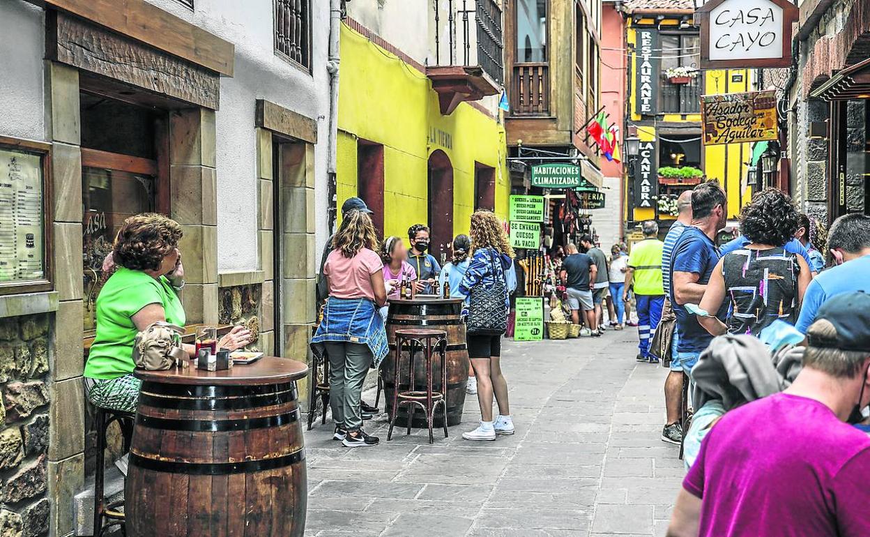 Vecinos y turistas llenan las terrazas de los bares y restaurantes situados en una de las calles principales de Potes, uno de los municipios participantes en la convocatoria de fondos europeos. 