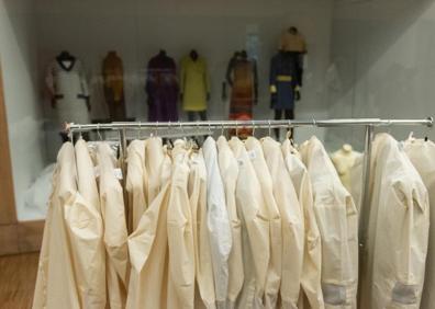 Imagen secundaria 1 - Arriba y abajo a la derecha, la directora del museo muestra prendas protegidas en uno de los armarios compactos. Abajo a la izquierda, prendas en su funda durante el montaje de la exposición permanente. 