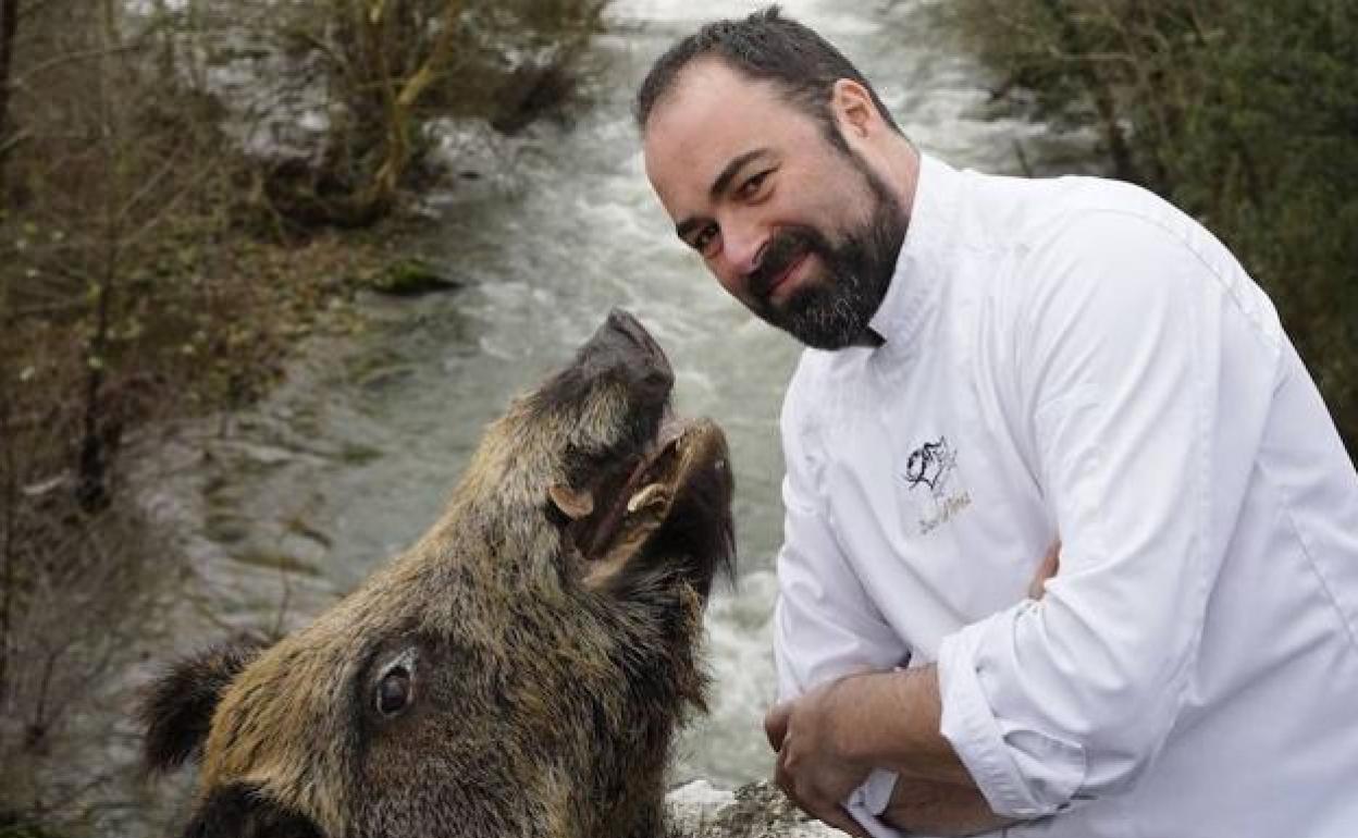 David Pérez Gutiérrez 'Ronquillo', posa junto al cauce del Asón con una cabeza de jabalí, icono de su local de Ramales de la Victoria. 