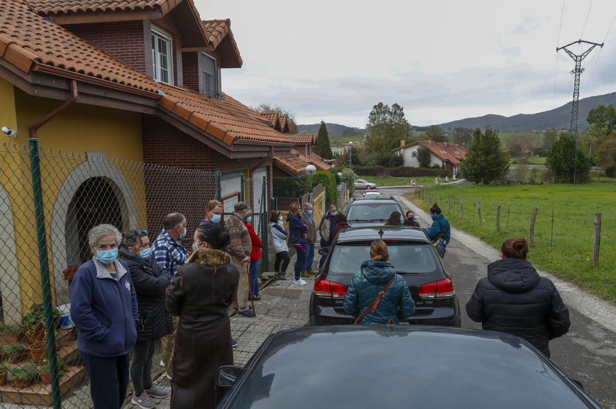 Una veintena de vecinos de la localidad de Penagos, ayer, en el barrio donde se encuentra el chalé okupado, al final de la calle.