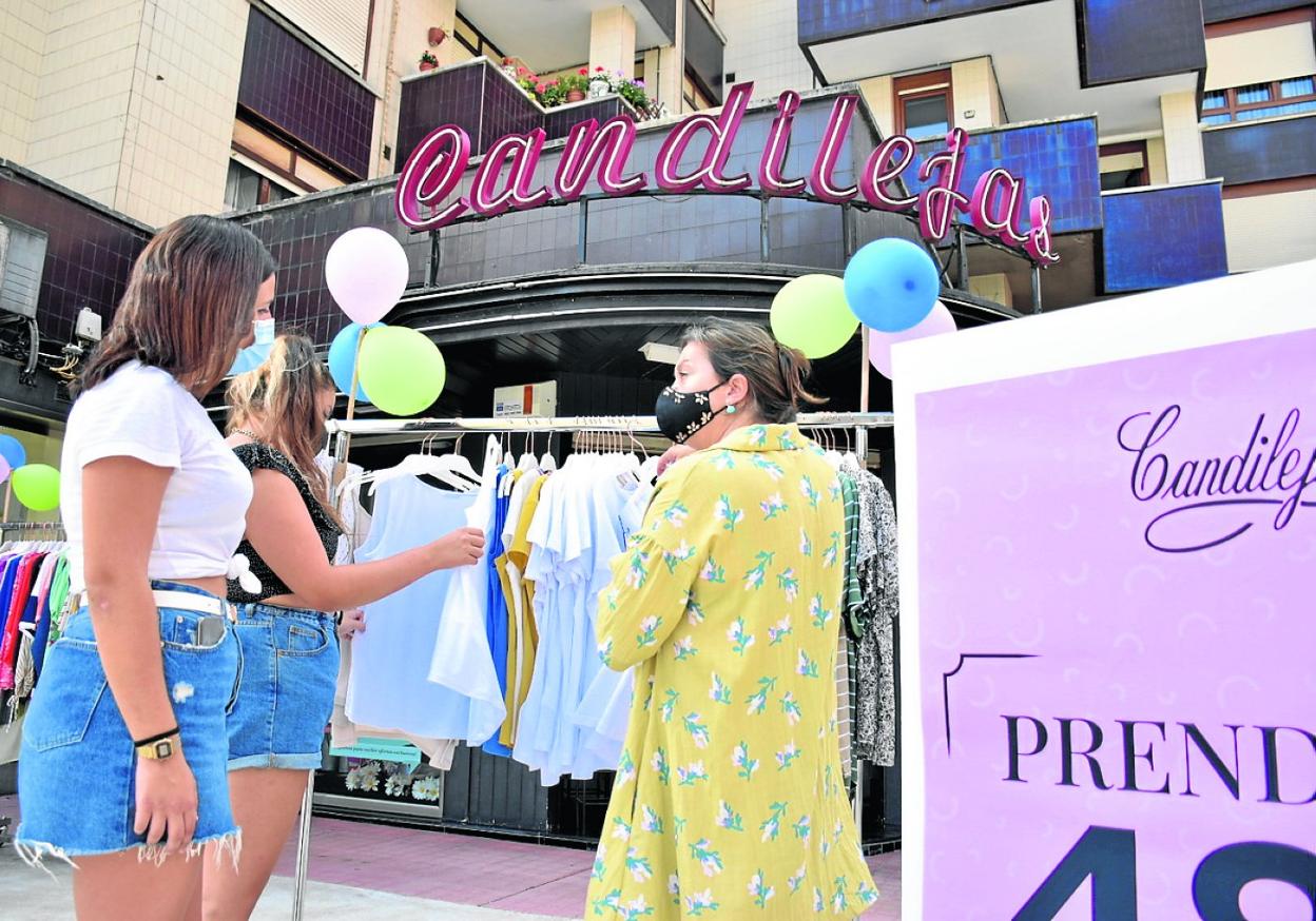 Clientas ojean unas prendas de ropa en una tienda del casco urbano, el año pasado, en Camargo. 