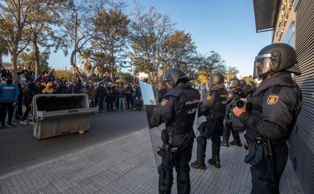 Antidisturbios vigilan a trabajadores del sector del metal.