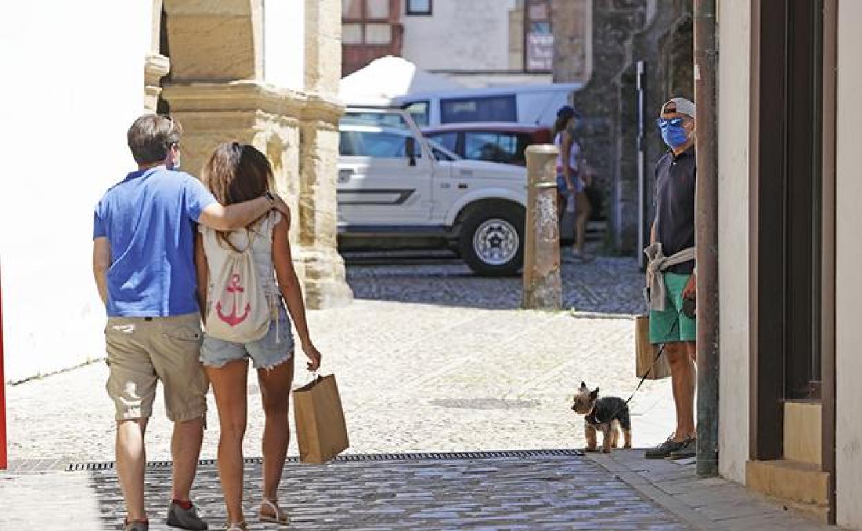 Una pareja pasea por el centro de Comillas. 