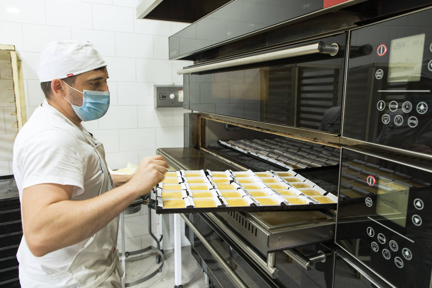 Uno de los obradores de Luca poniendo los sobaos al horno en el obrador.