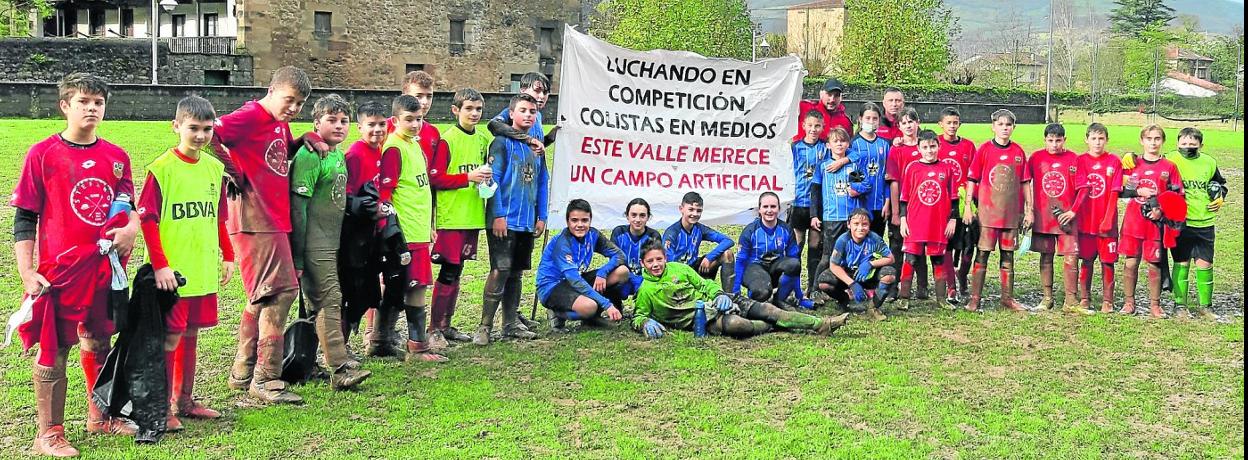 Jugadores de la categoría infantil del Arenas de Iguña y del Amistad de Sniace mostraron una pancarta tras el partido que jugaron recientemente en el campo de Arenas. 
