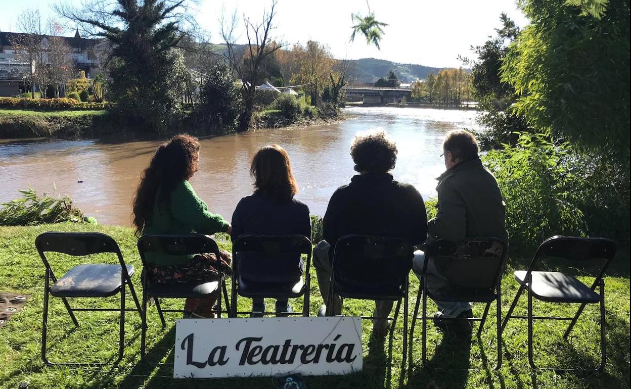 Integrantes de la compañía Ábrego Teatro junto el río Pas, que se desbordó la semana pasada e inundó su sede.