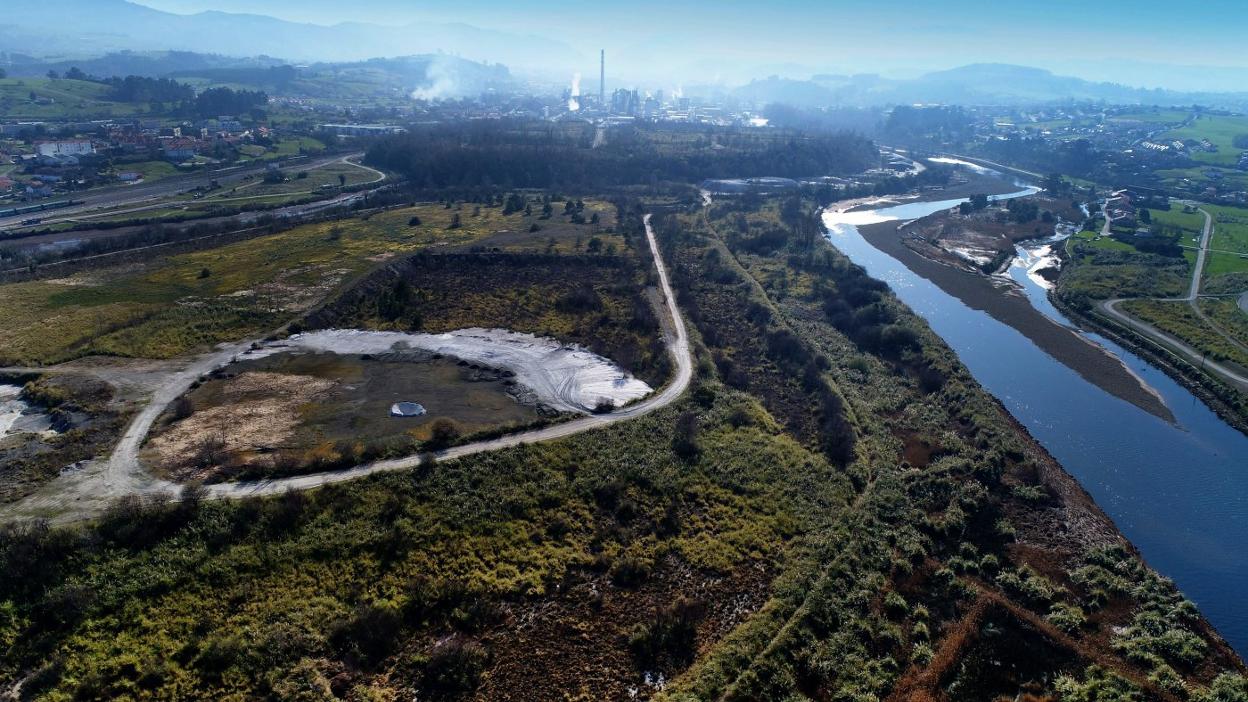 Imagen aérea de la isla de Monti, rodeada por el río Saja-Besaya, con la fábrica de Solvay al fondo. 