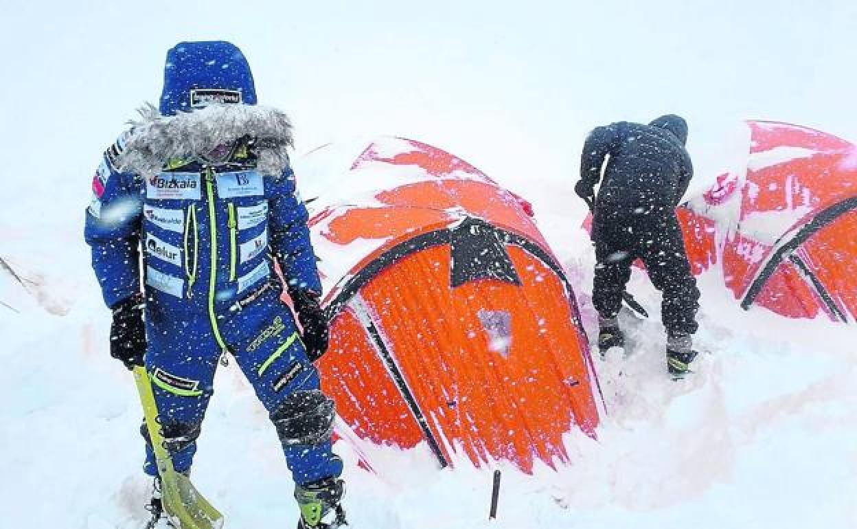 Txikon y otro compañero se afanan por retirar la nieve que cubre las tiendas en el CB. 