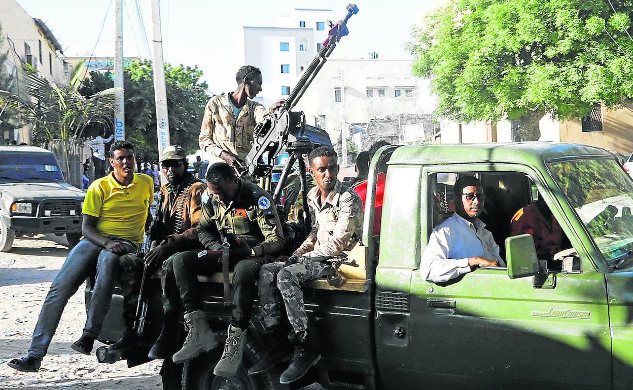 Militares afines al primer ministro Hussein Roble recorren en sus camionetas el distritio de Hodan en la capital, Mogadiscio.