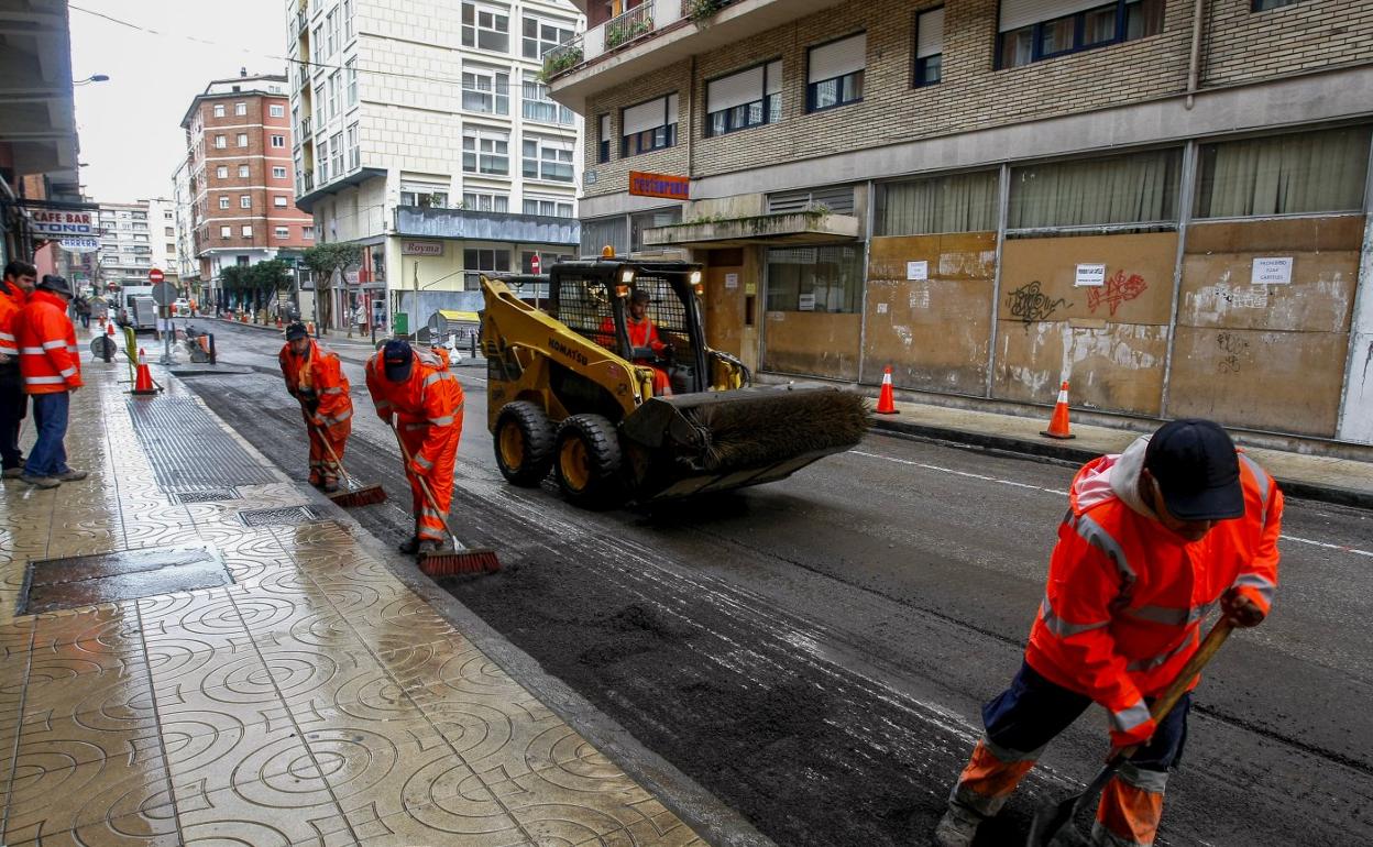 Unos operarios realizan trabajos de renovación del firme en el barrio de La Inmobiliaria. 