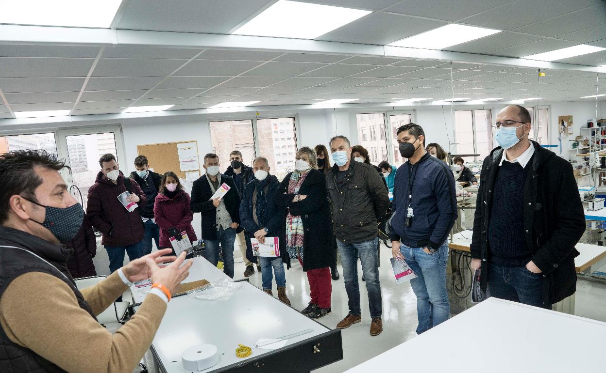 Miembros de la delegación internacional 'Líderes' y del equipo de gobierno de Camargo atienden durante la visita, este miércoles, en la sede de 'Nueva vida textil'. 