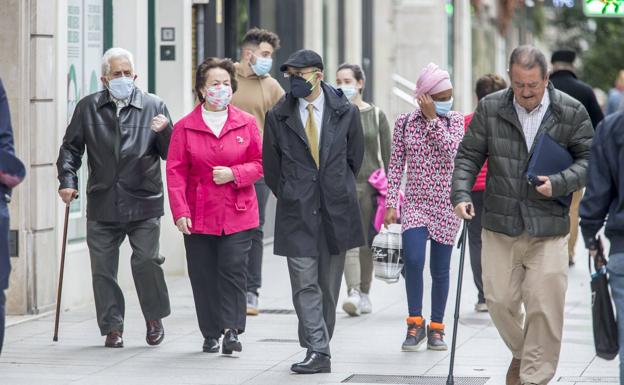 Imagen de arhivo de personas con mascarillas por la calle Juan de Herrera, en Santander. 