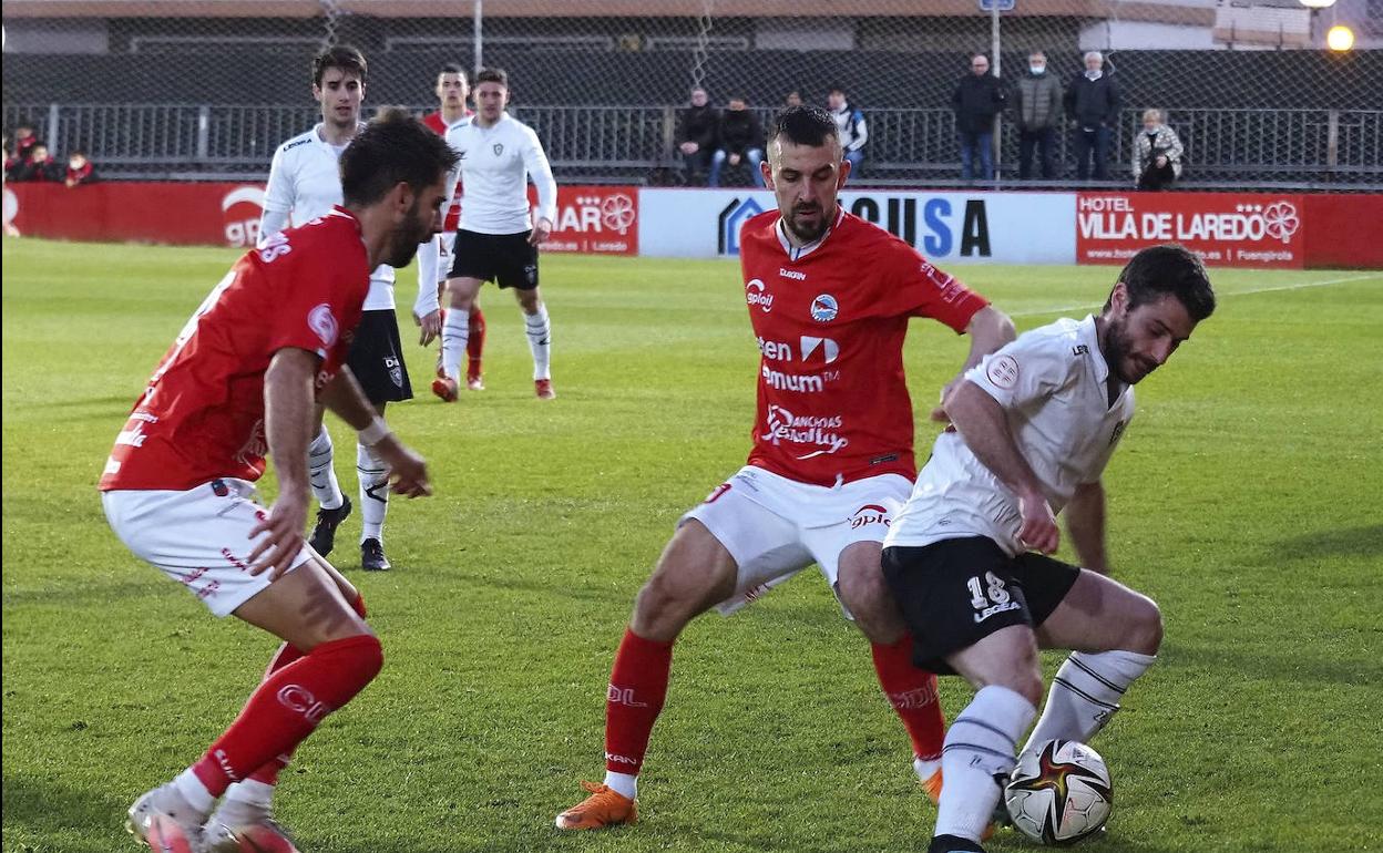 Argos y Vinatea tratan de robar el balón a Aguirre, del Gernika. 